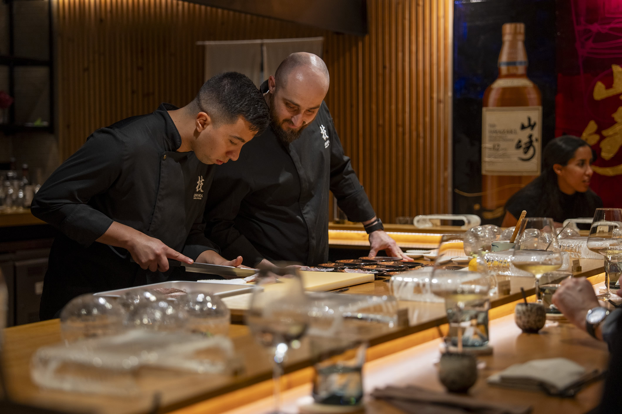 Chef Miguel Rodríguez at the Kno-Ma omakase bar, focused on plating techniques for the Patek Philippe and Relojería Alemana event in Palma.