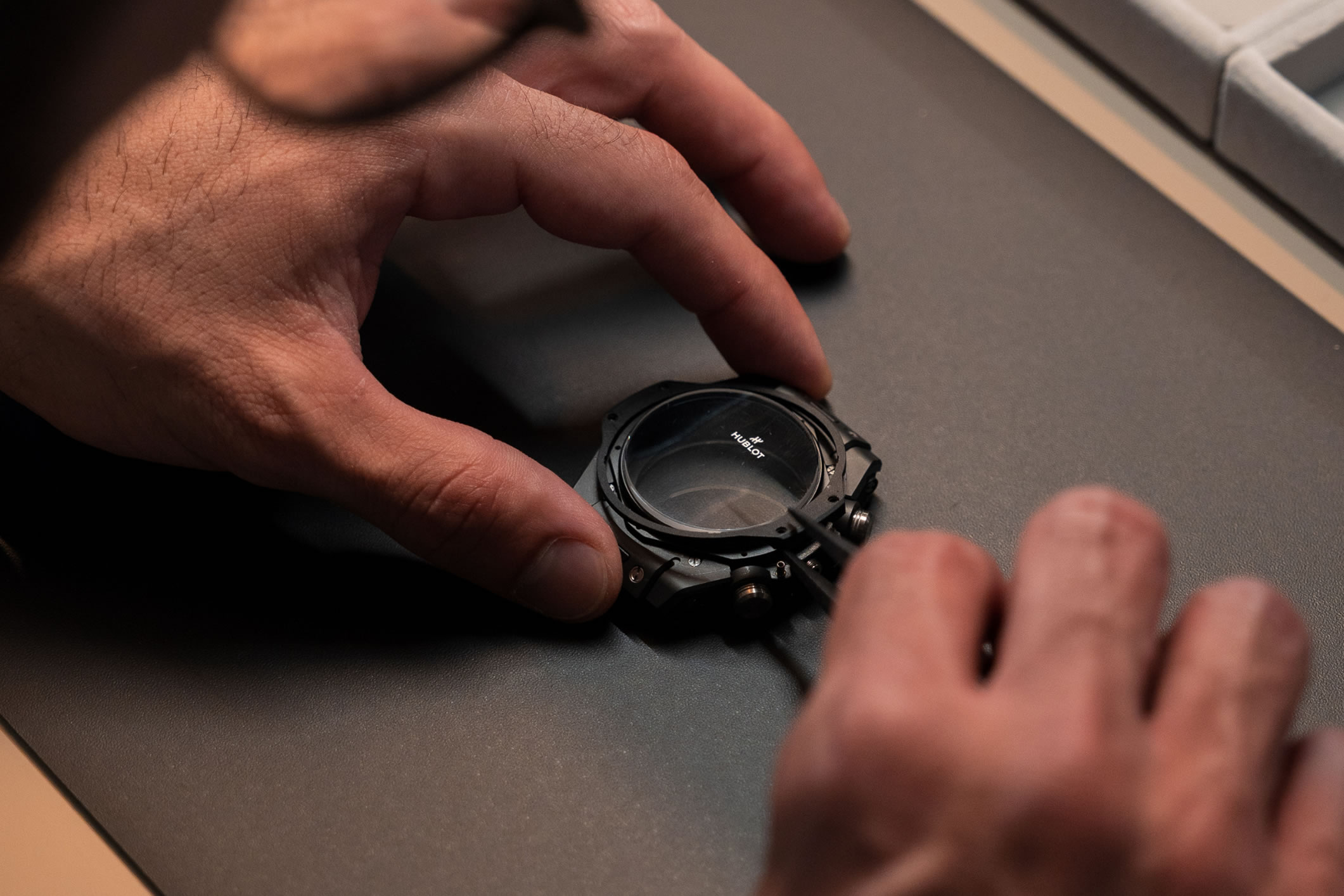 Manos trabajando en la caja de un reloj Hublot Big Bang durante una clase de relojería