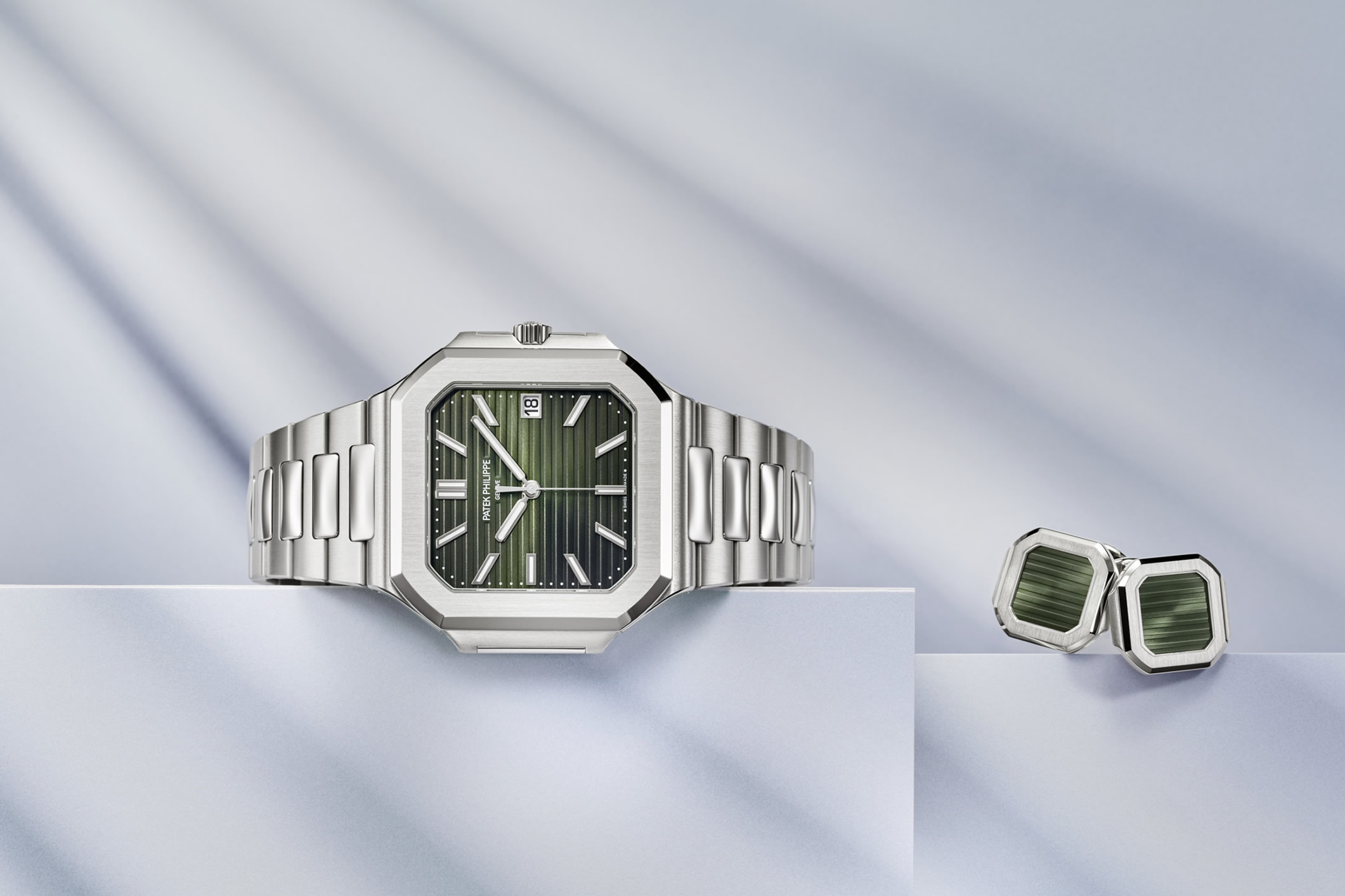 Patek Philippe Cubitus watch reference 5821/1A with a sunburst olive green dial and steel bracelet, alongside matching cufflinks