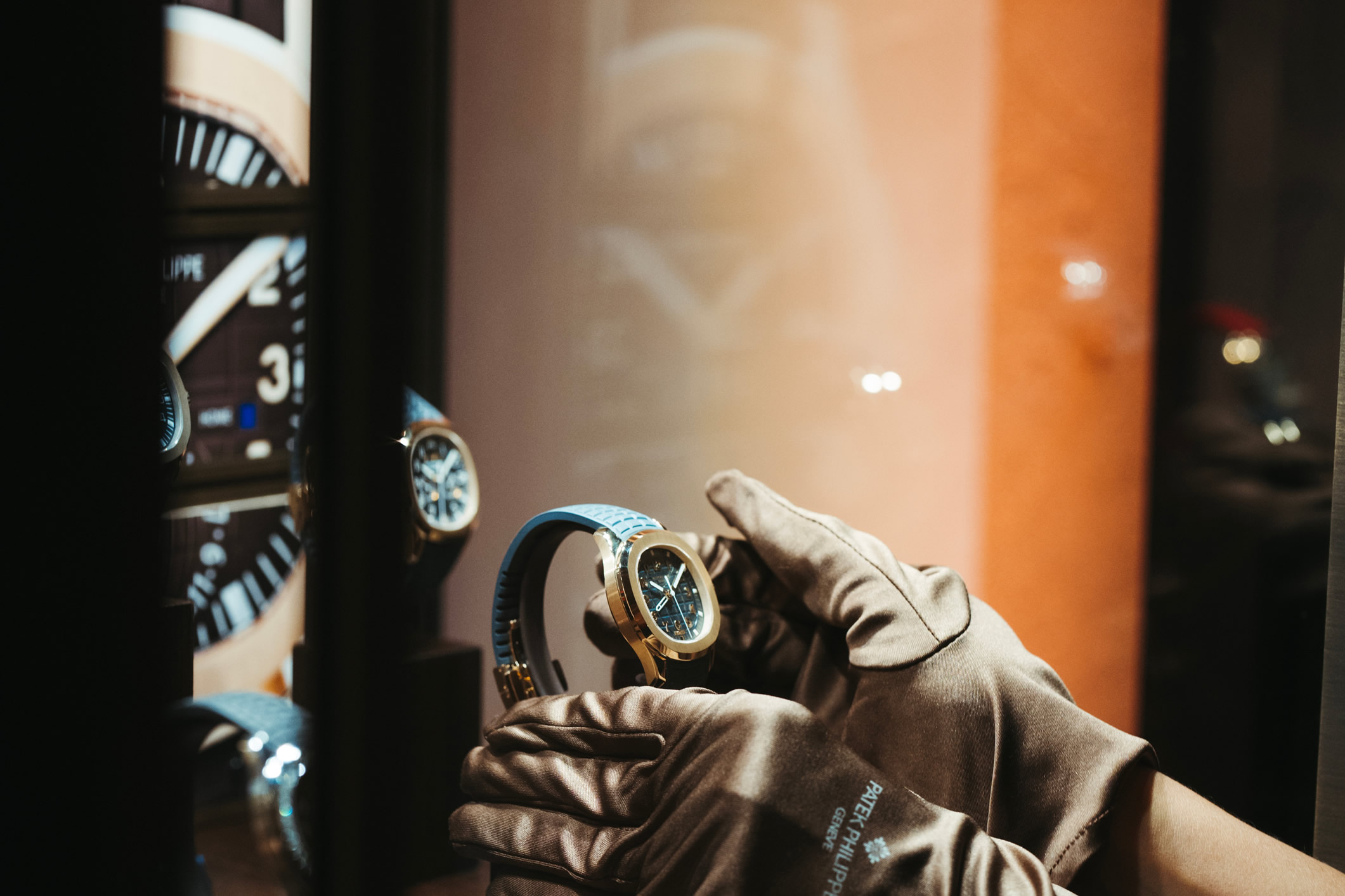 Reloj Patek Philippe Aquanaut con caja de oro rosa y correa de caucho color azul saliendo de la vitrina