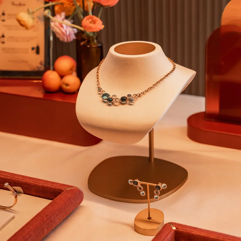 Collar de Pomellato en oro rosa con gemas de colores, presentados en un elegante display floral durante un evento privado de la firma.